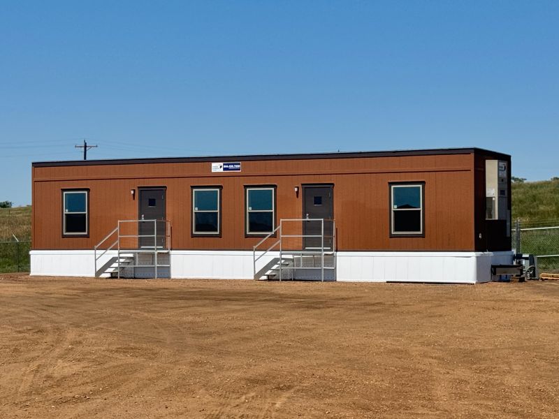 Complete commercial temporary site setup with fencing, office trailer, and equipment