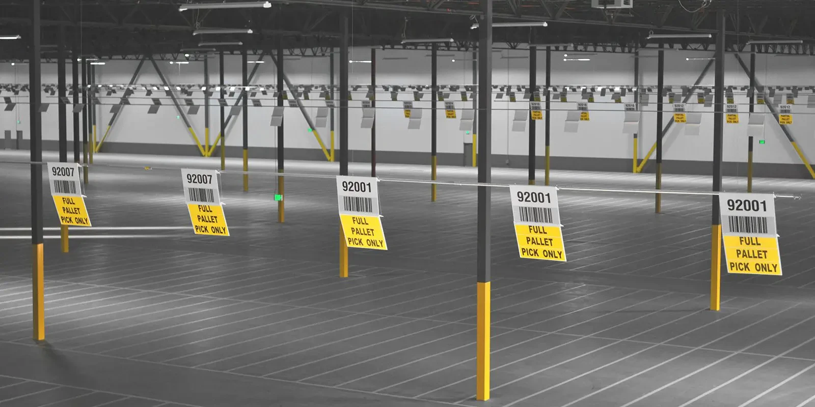 Suspended location signs above marked warehouse staging areas